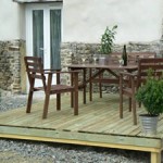 Gite Poppy in Normandy, France. Terrace with wooden garden furniture and barbeque